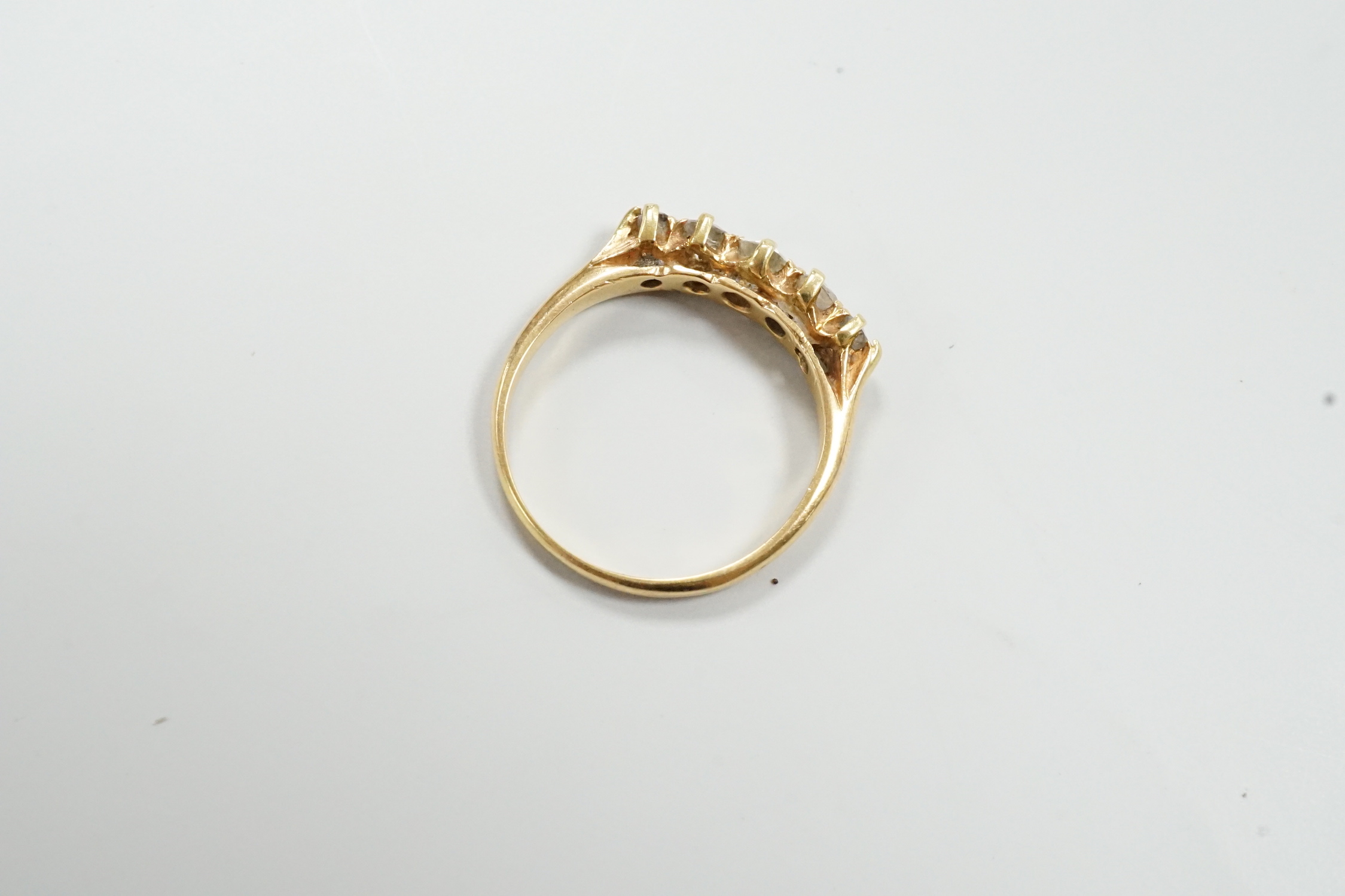 A gold and graduated five stone diamond set half hoop ring, size O/P, gross weight 2.8 grams.